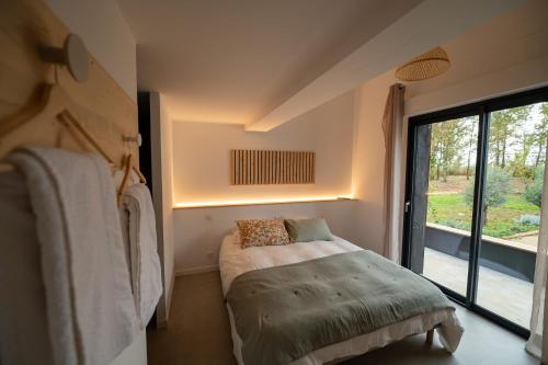 a small bedroom with a bed and a window at La Casa M-maison idéale pour groupes familles amis 12 personnes au calme avec piscine in Sainte-Hélène