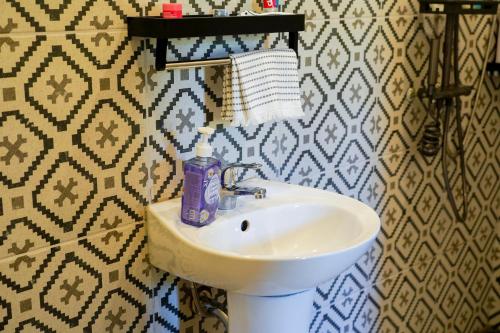 a bathroom with a sink and a bottle of soap at Aman House in San Vicente
