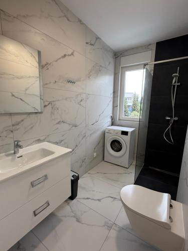 a bathroom with a sink and a washing machine at Astrid Deluxe in Novalja