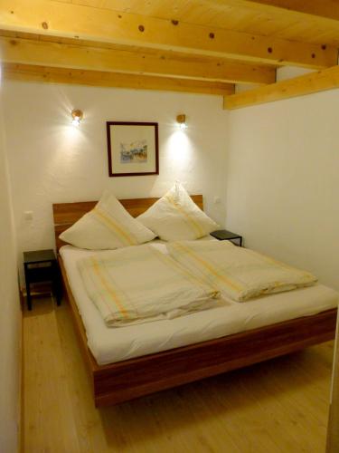a bed with white sheets and pillows in a bedroom at Haus Berger in Bad Reichenhall