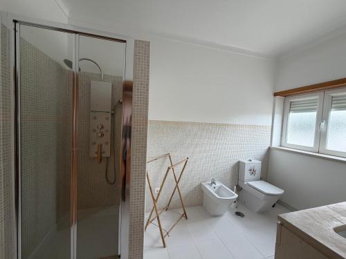 a bathroom with a shower and a toilet at Casa da Tininha in Alcobaça