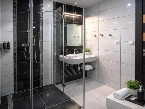 a bathroom with a glass shower and a sink at Vila GARUFA Wellness & Spa in Vysoké Tatry