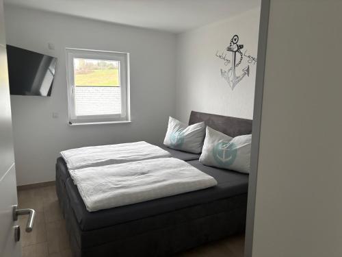 a bedroom with a bed and a window at Ferienwohnungen Hafenwerk in Braunsbedra