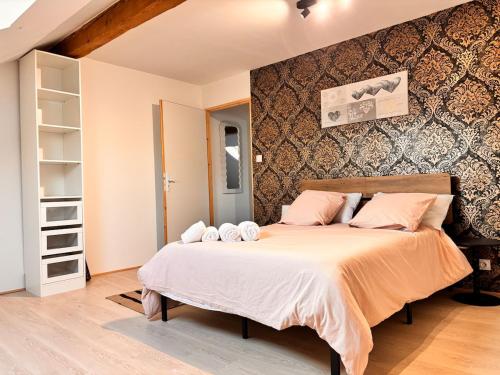 a bedroom with a large bed with pink pillows at Votre cocon vosgien in Saint-Étienne-lès-Remiremont