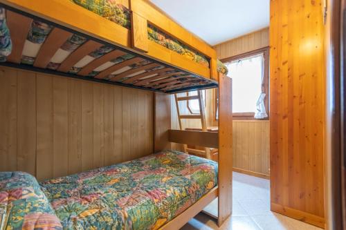 a bedroom with two bunk beds and a window at Appartamento Mondeval in Selva di Cadore