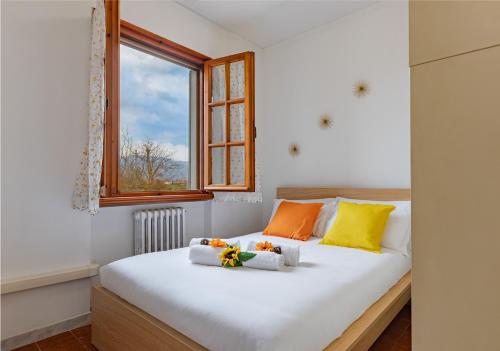a bedroom with a white bed with orange and yellow pillows at Hostly G&G Home in Pisa