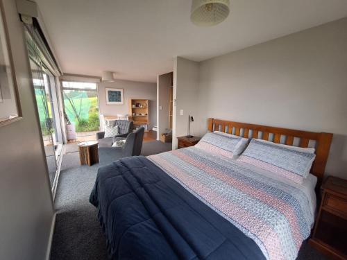 a bedroom with a bed and a living room at Addictive View - Lakeside Studio in Rotorua