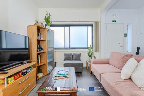 a living room with a couch and a tv at Vagabond Mermaid Guesthouse in Ponta Delgada