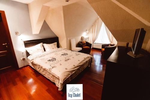 ein Schlafzimmer mit einem Bett und einem Fernseher in der Unterkunft Icy Chalet in Predeal