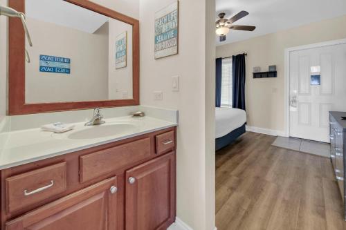 a bathroom with a sink and a mirror and a bedroom at Carillon Beach Inn 310 in Panama City Beach