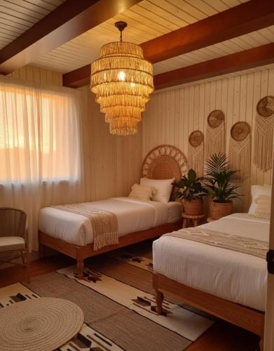 a bedroom with two beds and a chandelier at Amber Dahabiya in Luxor