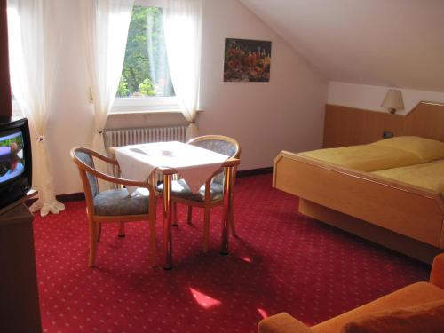 a hotel room with a table and chairs and a bed at Hotel Goldbächel in Wachenheim an der Weinstraße