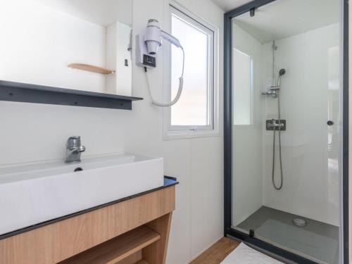 a bathroom with a sink and a shower at Camping Le Platin - La Redoute in Rivedoux-Plage