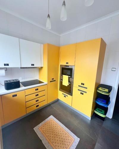 a kitchen with yellow cabinets and a yellow refrigerator at Vagabond Mermaid Guesthouse in Ponta Delgada