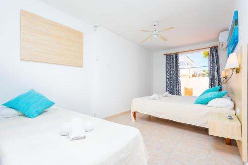 a bedroom with two beds and a window at Hotel Antares in Cala d´Or