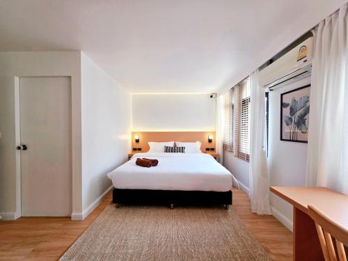 a bedroom with a large white bed and a window at Baan Rak BTS phromphong Emsphere in Bangkok