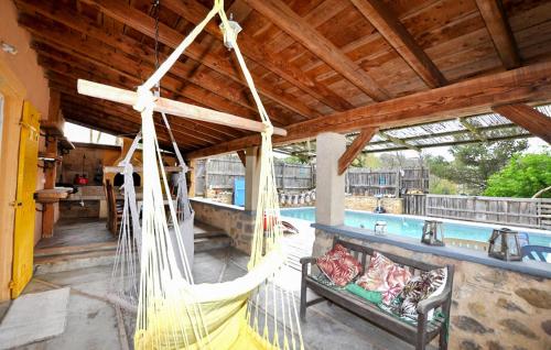a porch with a hammock and a pool at Authentique Maison Piscine in La Cassaigne