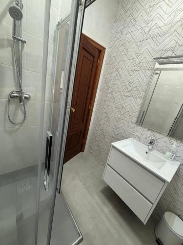 a bathroom with a sink and a shower and a mirror at A casa do Cabezo in Mougás