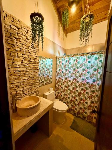 a bathroom with a sink and a stone wall at Casa Del Cielo in Jarabacoa