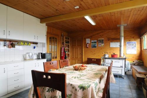 a kitchen with a table and chairs in a room at Casa Pindal in Puqueldón
