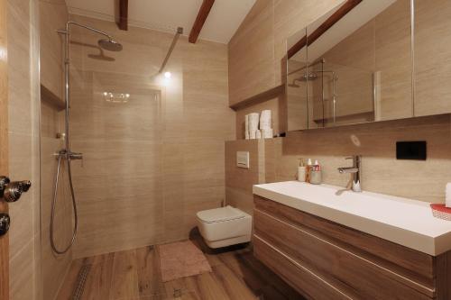 a bathroom with a toilet and a sink and a shower at Seraphine Chalet in Peje