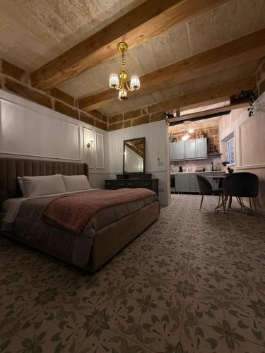 a bedroom with a bed and a desk and a kitchen at Ta' Marta Lodge in Victoria