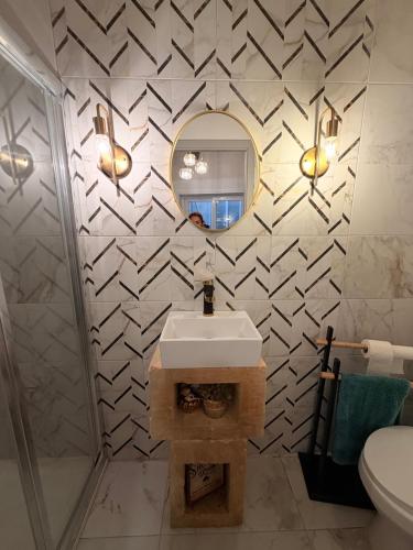 a bathroom with a sink and a mirror at Ta' Marta Lodge in Victoria