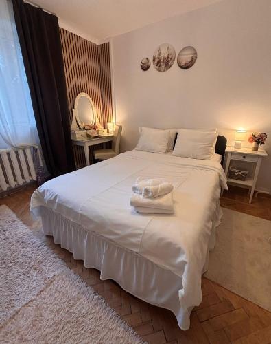 a bedroom with a white bed with towels on it at Sleep & Go Floreasca Green in Bucharest