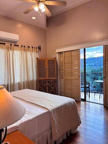 a bedroom with a bed and a balcony with a view at Sophia Suites Residence Hotel in Cebu City