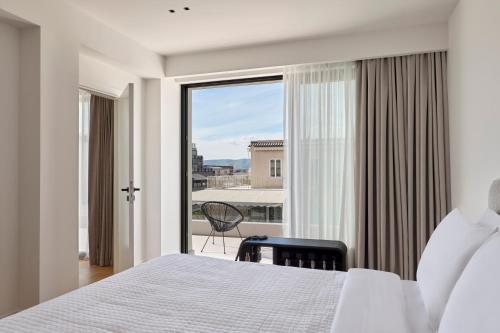 a bedroom with a bed and a large window at September Athens Residences in Athens