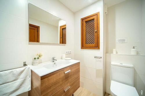 a bathroom with a sink and a toilet and a mirror at Piso Marina by Sealand Villas in Port de Pollensa