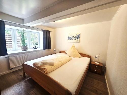 a bedroom with a large bed with a window at Uijs Hüs in Borgsum