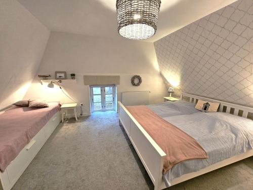 a bedroom with two beds and a clock on the wall at WattLütt in Oevenum