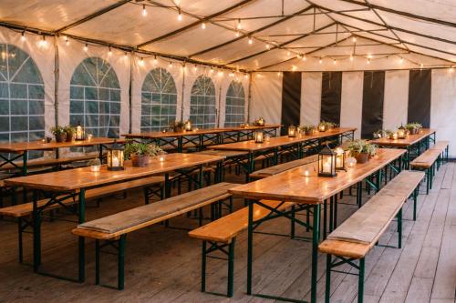 a row of tables in a marquee with lights at Camping Les Pommiers in Comblain-au-Pont