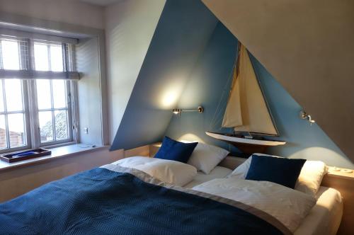 a bedroom with a bed with a sailboat on the wall at Reethus Haupthaus im EG OG in Borgsum