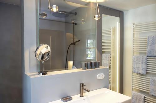 a bathroom with a sink and a mirror at Reethus Haupthaus im EG OG in Borgsum