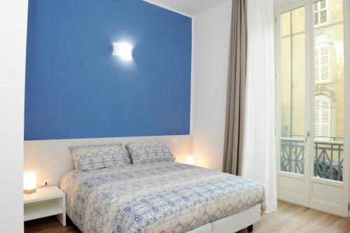 a blue bedroom with a bed and a window at Torino 1854 Affittacamere in Turin