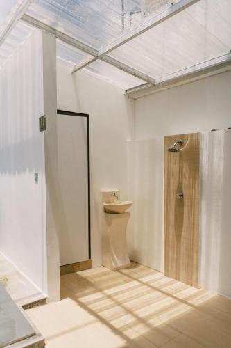 a bathroom with a shower and a toilet in a room at Domu Alba Vita in Denpasar
