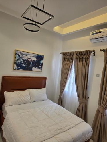 a bedroom with a bed and a window with curtains at BJ Home in Iseri-Oke