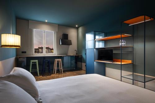 a bedroom with a bed and a kitchen with a bar at Le Stanze Di Vittoria in Cesenatico