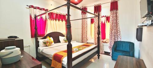 a bedroom with a four poster bed with red curtains at RUDRAKSH HOTEL & RESTAURANT in Kumbhalgarh in Kumbhalgarh