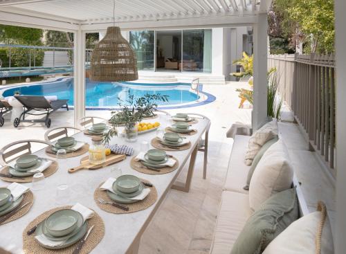 a patio with a table and chairs and a pool at Villa Stefani with Private Pool in Athens