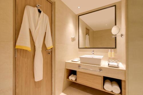a bathroom with a sink and a mirror at Lemon Tree Hotel, Bhubaneswar in Bhubaneshwar