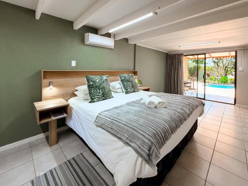 a bedroom with a large bed with green walls at 12 On Churchill in George