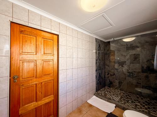 a bathroom with a toilet and a wooden door at 12 On Churchill in George
