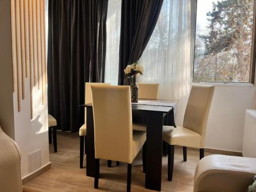 a dining room with a table and chairs and a window at Sleep & Go Floreasca Green in Bucharest
