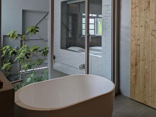 a white bath tub in a bathroom with a window at 都蘭小星民宿 Dulan Star Guest House in Donghe