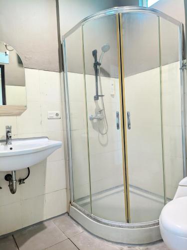 a shower stall in a bathroom with a sink at K Residence Surabaya in Surabaya