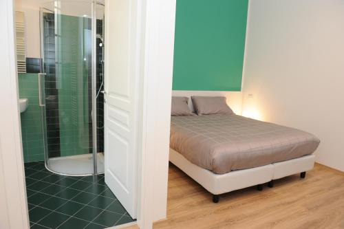 a small bedroom with a bed and a shower at Torino 1854 Affittacamere in Turin