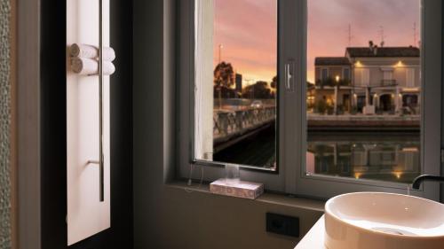 a bathroom with a sink and a window with a view at Le Stanze Di Vittoria in Cesenatico